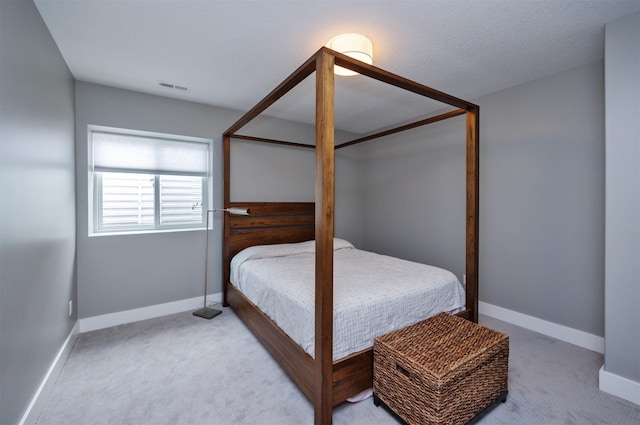 bedroom with light colored carpet, baseboards, and visible vents