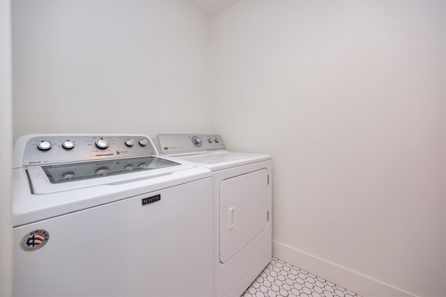 laundry area featuring laundry area, baseboards, and washing machine and dryer