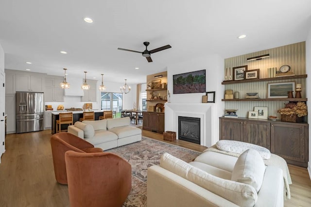 living room with ceiling fan, recessed lighting, and wood finished floors