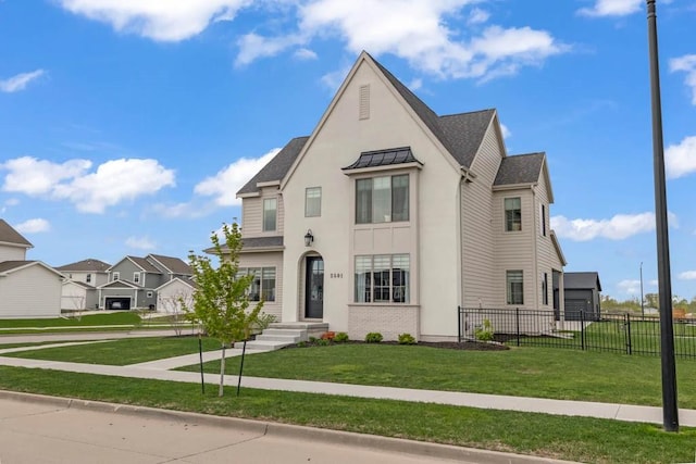 french provincial home featuring fence, a shingled roof, a standing seam roof, and a front lawn