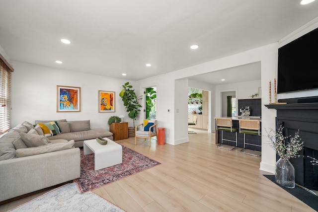 living area featuring recessed lighting, baseboards, and light wood finished floors