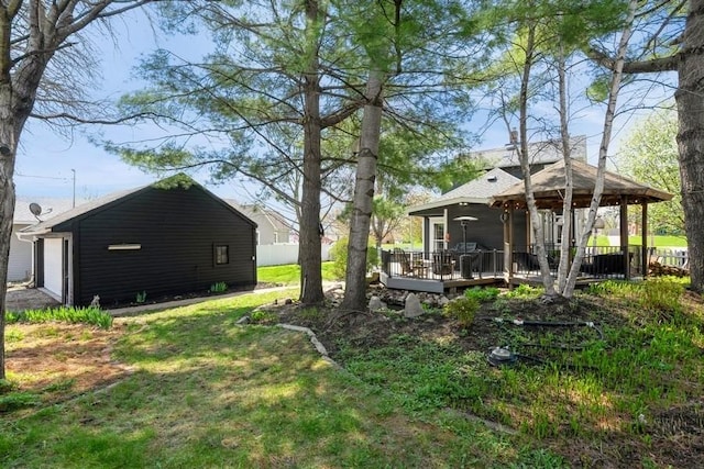 view of yard featuring a gazebo, an outdoor structure, a wooden deck, and a detached garage
