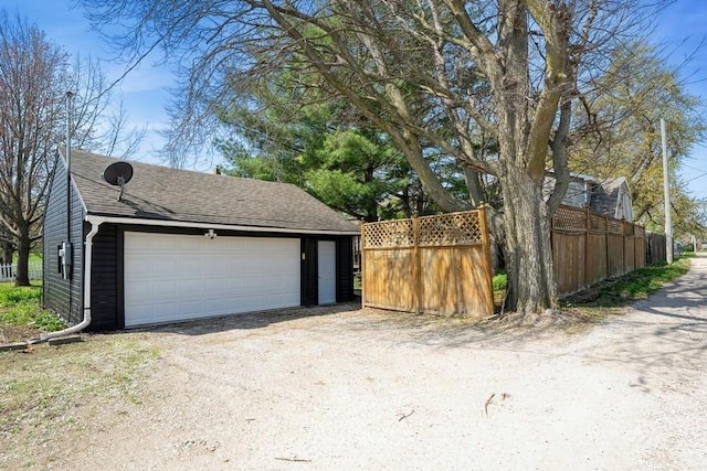 detached garage featuring fence
