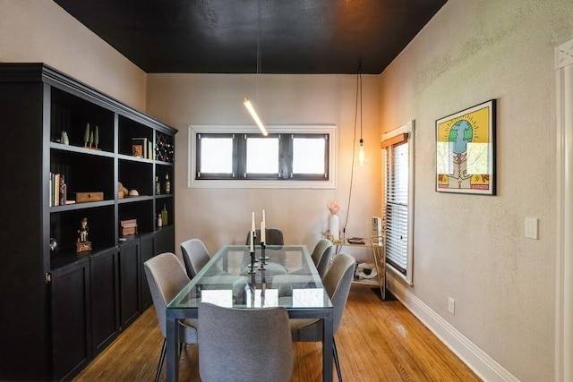 dining space featuring baseboards and wood finished floors