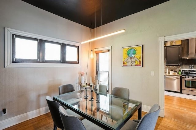 dining area with light wood-style floors and baseboards