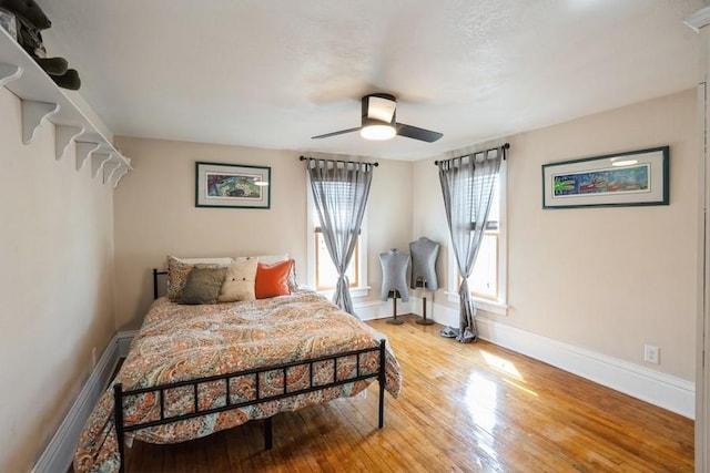 bedroom with baseboards, ceiling fan, and light wood finished floors