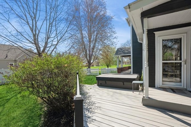 deck featuring a hot tub and fence