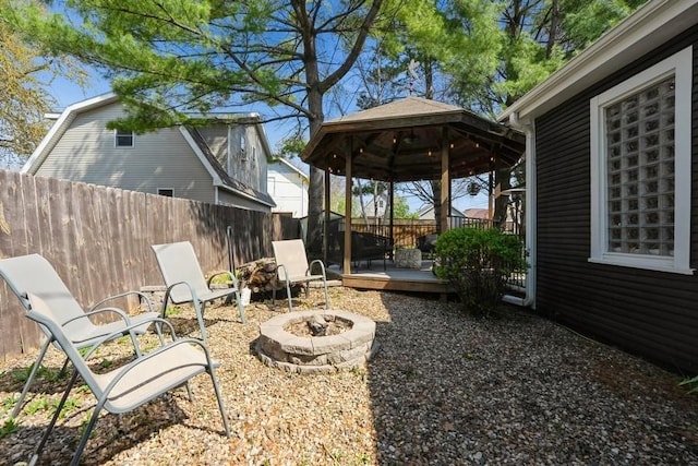 view of yard with a deck, a gazebo, fence, and an outdoor fire pit