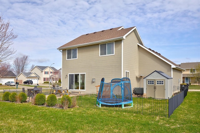 520 SE Murphy Dr, Waukee, IA 50263 - back of house featuring a storage unit, a trampoline, and a yard