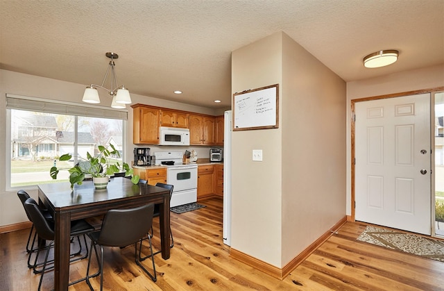 520 SE Murphy Dr, Waukee, IA 50263 - kitchen with white appliances, baseboards, and light wood-type flooring