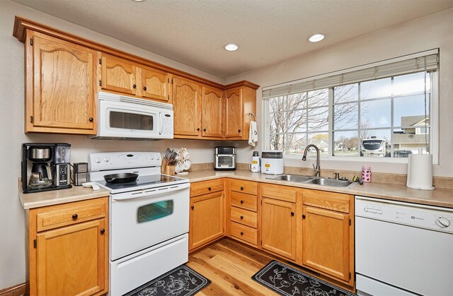 520 SE Murphy Dr, Waukee, IA 50263 - kitchen featuring white appliances, light countertops, a sink, and light wood-style floors