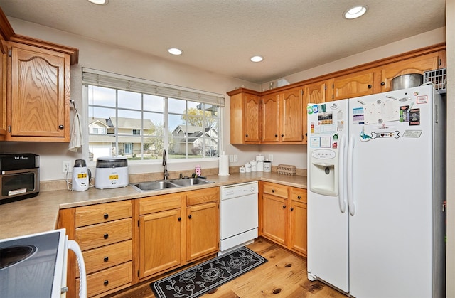 520 SE Murphy Dr, Waukee, IA 50263 - kitchen featuring a sink, light countertops, light wood finished floors, recessed lighting, and white appliances