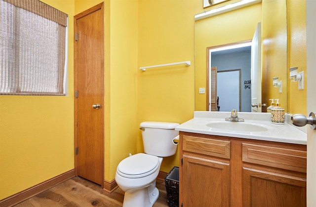520 SE Murphy Dr, Waukee, IA 50263 - half bathroom featuring vanity, baseboards, toilet, and wood finished floors