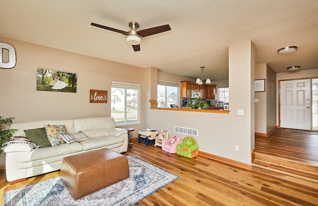 520 SE Murphy Dr, Waukee, IA 50263 - living room featuring a ceiling fan, baseboards, visible vents, and wood finished floors