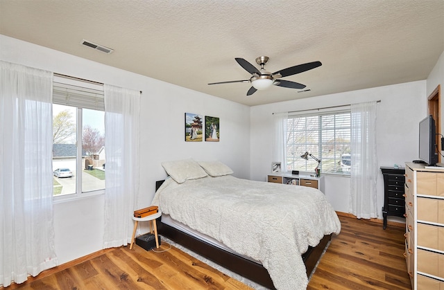 520 SE Murphy Dr, Waukee, IA 50263 - bedroom with multiple windows, wood finished floors, and visible vents