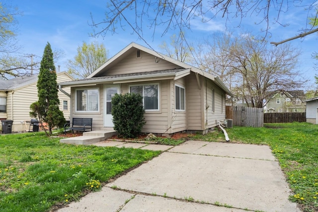 bungalow featuring a patio, fence, and a front lawn