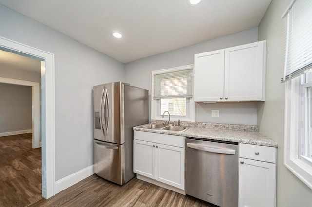 kitchen featuring baseboards, dark wood-style floors, white cabinetry, a sink, and appliances with stainless steel finishes
