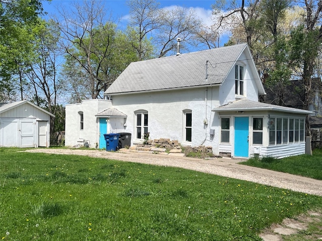 2104 23rd St, Des Moines, IA 50310 - view of front of home featuring a front yard, a sunroom, a shingled roof, a storage shed, and an outbuilding