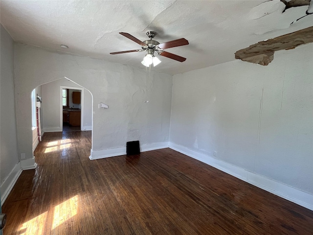2104 23rd St, Des Moines, IA 50310 - unfurnished room featuring arched walkways, ceiling fan, baseboards, and dark wood-style floors