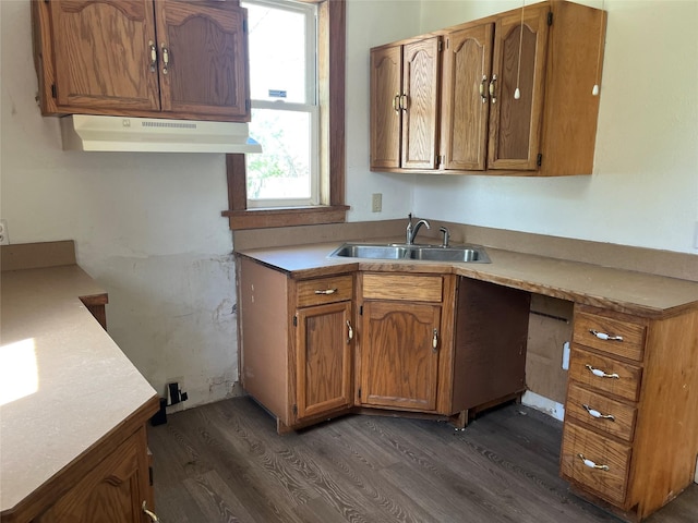 2104 23rd St, Des Moines, IA 50310 - kitchen with brown cabinets, dark wood finished floors, a sink, light countertops, and under cabinet range hood