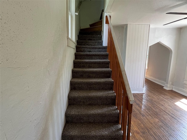 2104 23rd St, Des Moines, IA 50310 - stairway with a ceiling fan, arched walkways, wood finished floors, baseboards, and a textured wall