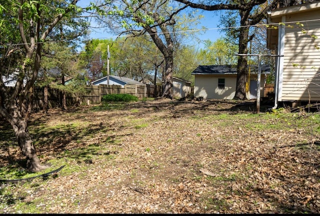 view of yard featuring fence and an outdoor structure