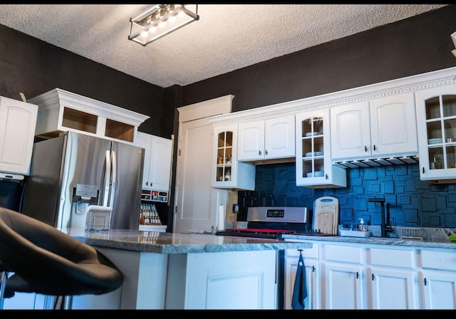 kitchen featuring white cabinets, stainless steel appliances, and decorative backsplash