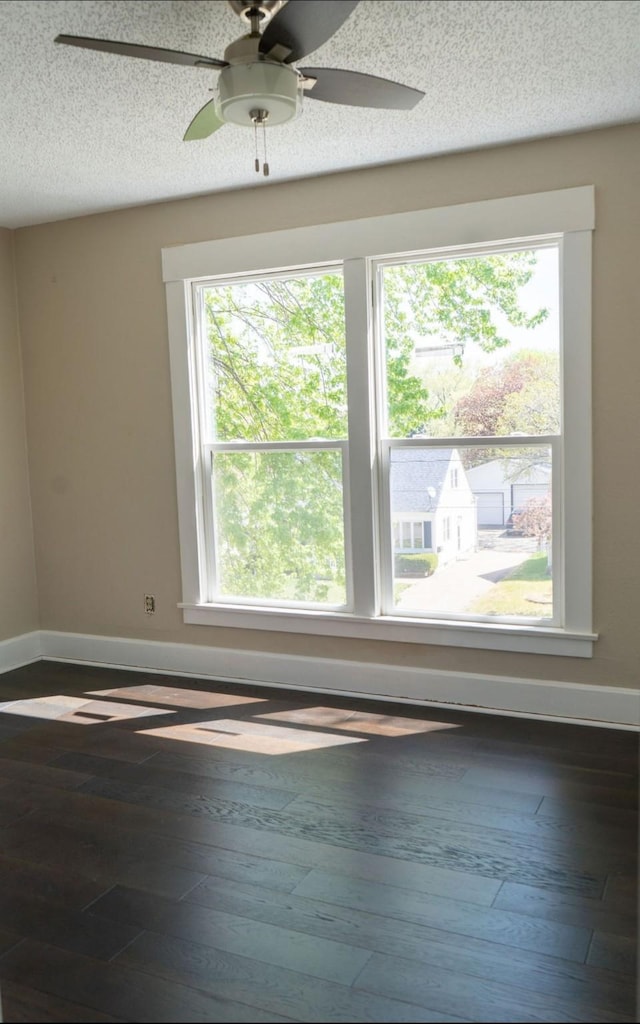 unfurnished room with baseboards, hardwood / wood-style flooring, and a wealth of natural light