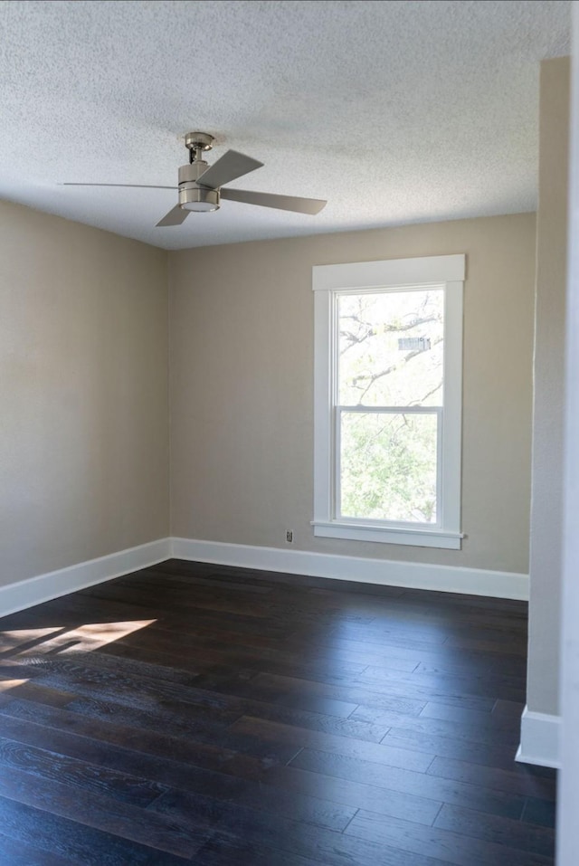 spare room with baseboards, ceiling fan, dark wood-style flooring, and a textured ceiling