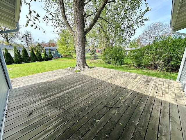 wooden deck featuring a lawn