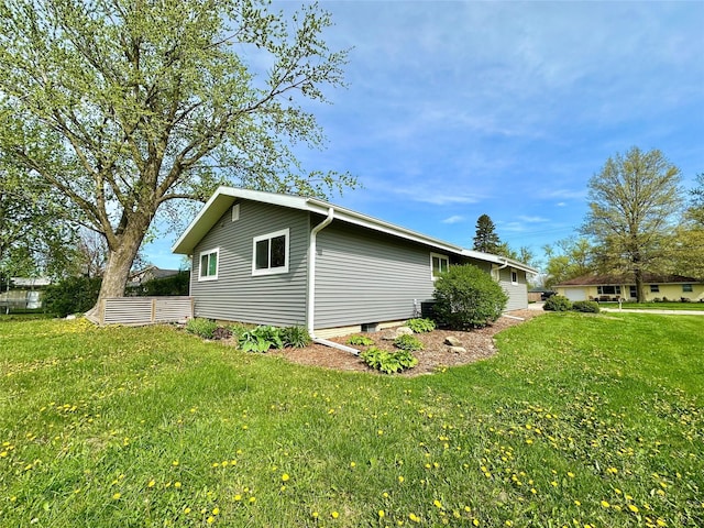 view of side of home with a yard