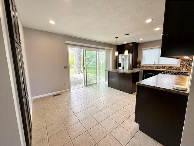 kitchen with stainless steel appliances, recessed lighting, backsplash, a kitchen island, and visible vents