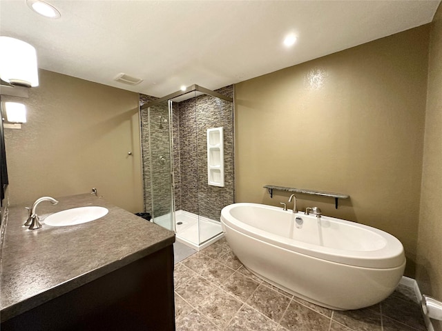 full bath with vanity, a stall shower, and a soaking tub