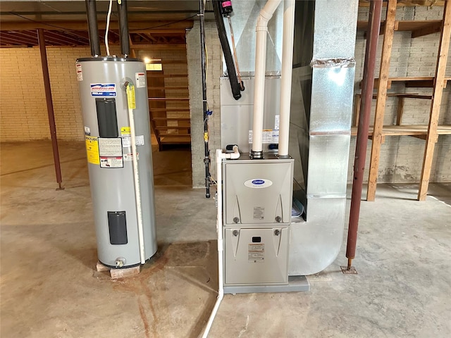 utility room featuring heating unit and electric water heater