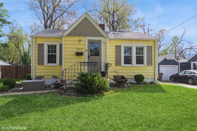 bungalow-style home with fence, a front lawn, board and batten siding, a chimney, and driveway