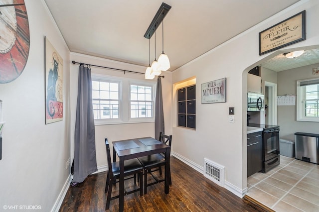dining area with baseboards, wood finished floors, and visible vents