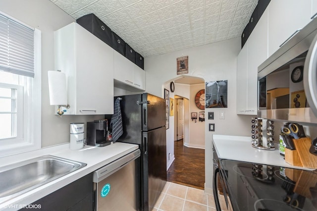 kitchen with light countertops, white cabinets, an ornate ceiling, and black appliances