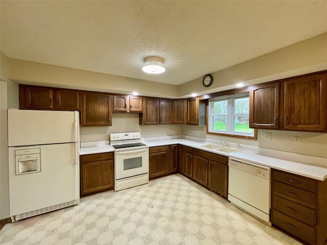 kitchen featuring a sink, light floors, white appliances, and light countertops