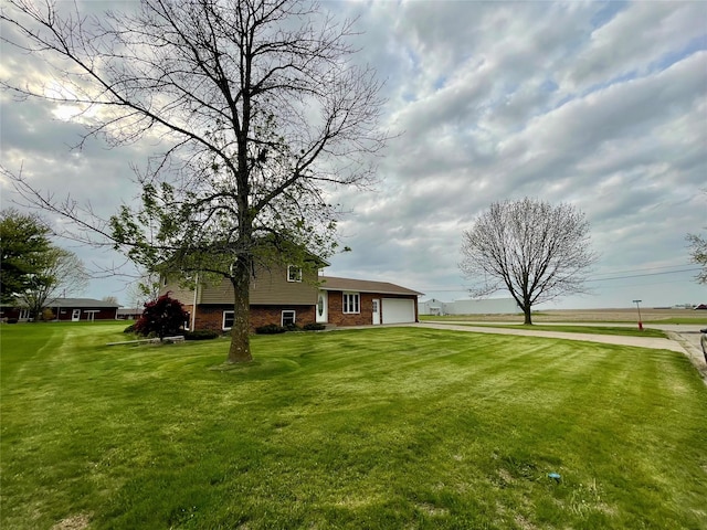 view of yard with a garage and driveway