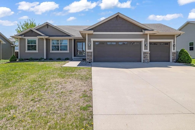 craftsman-style house featuring an attached garage, a front lawn, driveway, and stone siding