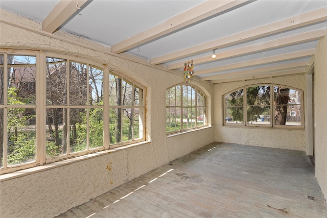 unfurnished sunroom with beamed ceiling