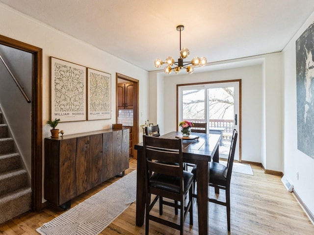 dining space with visible vents, stairway, baseboards, a chandelier, and light wood-style flooring