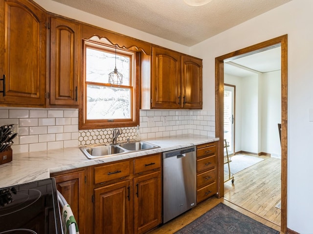 kitchen with electric range, a sink, light countertops, wood finished floors, and stainless steel dishwasher