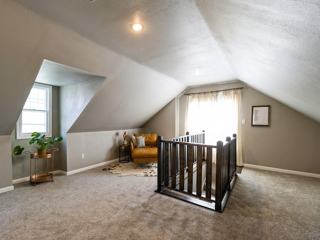 bonus room with carpet floors, a textured ceiling, baseboards, and vaulted ceiling