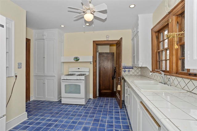 5502 Ingersoll Ave, Des Moines, IA 50312 - kitchen featuring tile counters, a sink, white cabinetry, and gas range gas stove