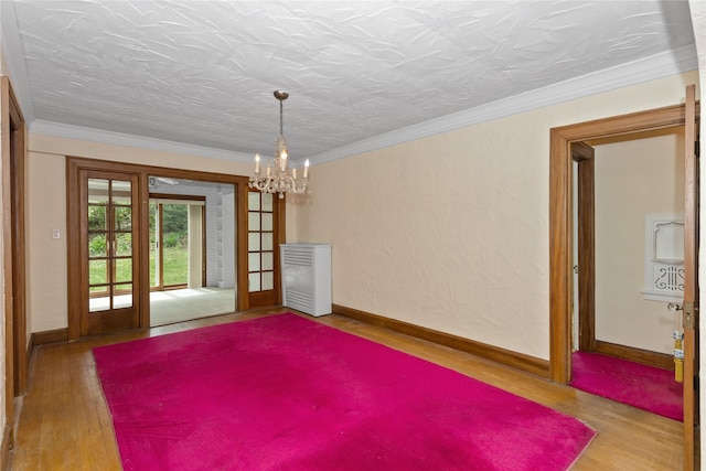 5502 Ingersoll Ave, Des Moines, IA 50312 - empty room featuring wood-type flooring, ornamental molding, baseboards, and an inviting chandelier