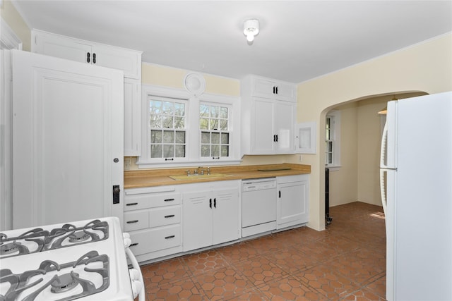 5502 Ingersoll Ave, Des Moines, IA 50312 - kitchen featuring arched walkways, a sink, white cabinets, butcher block counters, and white appliances