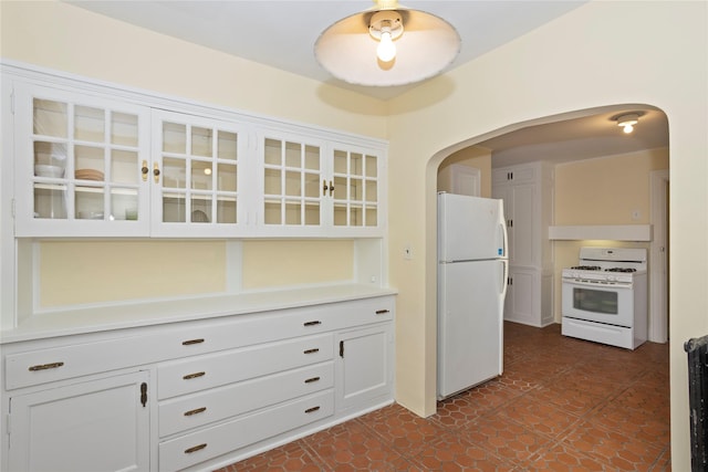 5502 Ingersoll Ave, Des Moines, IA 50312 - kitchen with white appliances, arched walkways, white cabinets, and glass insert cabinets