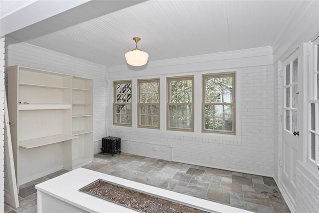 5502 Ingersoll Ave, Des Moines, IA 50312 - unfurnished dining area featuring stone tile flooring and crown molding
