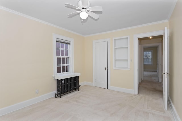 5502 Ingersoll Ave, Des Moines, IA 50312 - spare room featuring baseboards, ornamental molding, light carpet, and built in shelves